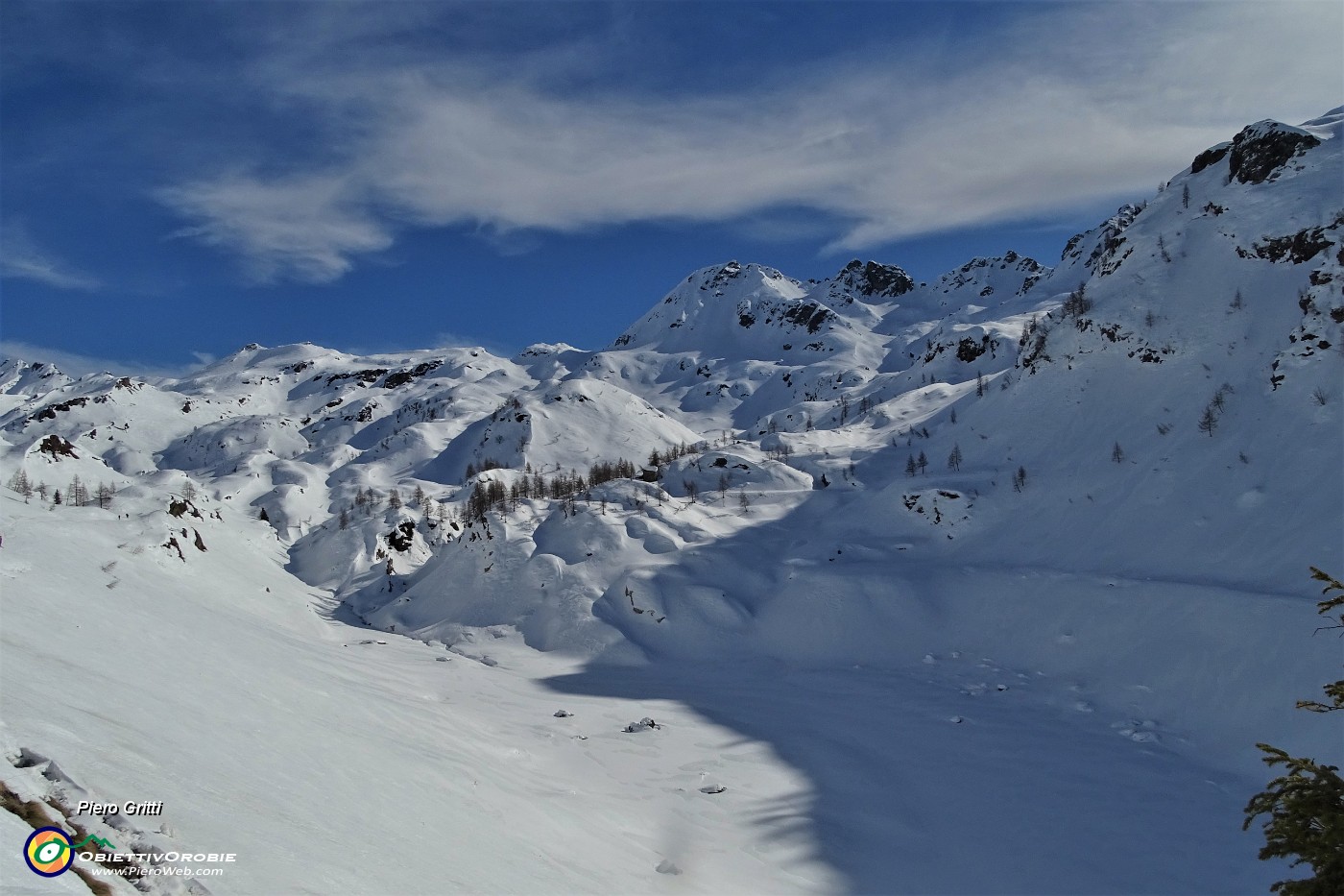56 In cammino sulla traccia scavata nella neve sul ripido pendio dell'invaso del lago ...senz'acqua, bianco di neve con vista sul Madonnino.JPG